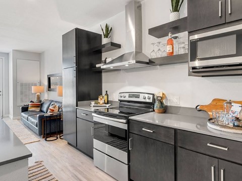 A modern kitchen with a black refrigerator and stove.