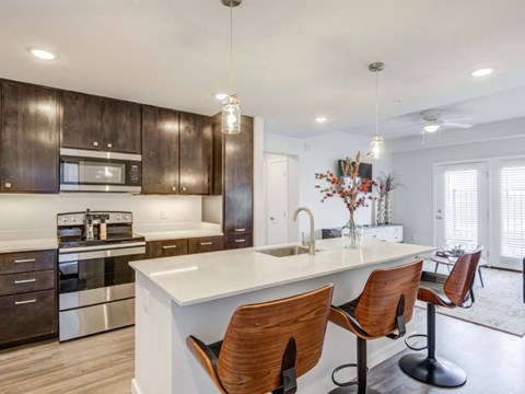 A modern kitchen with dark wood cabinets and a white island.