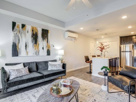 A modern living room with a black couch and a coffee table.