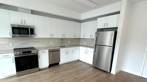 A kitchen with white cabinets and stainless steel appliances.