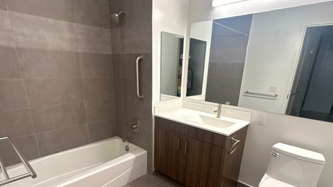 A bathroom with a white tub, sink, and toilet.