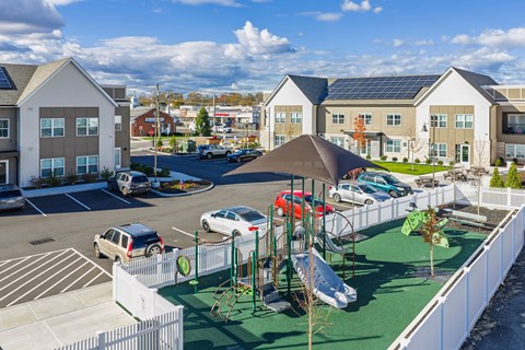 A playground with a slide and a green lawn.
