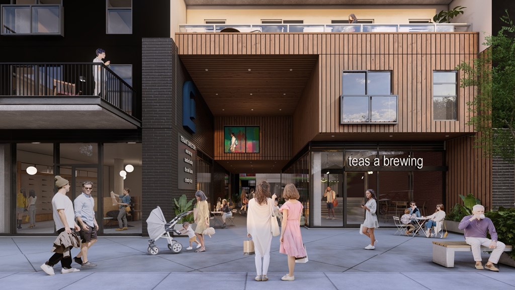 A group of people are walking in front of a building with a sign that says "teas a brewing".