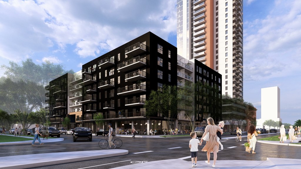 A modern building with a black facade is surrounded by taller buildings and a group of people are walking on the street.