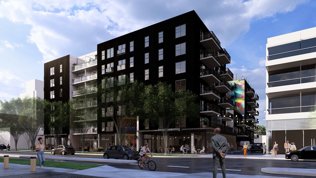 A black building with a green tree on the side.