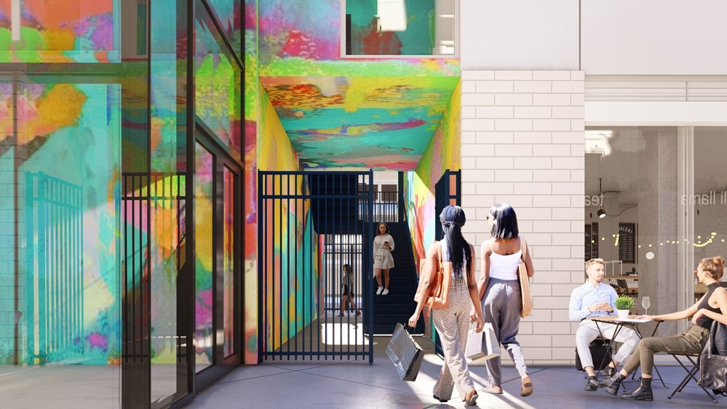 A group of people are walking through a colorful hallway.