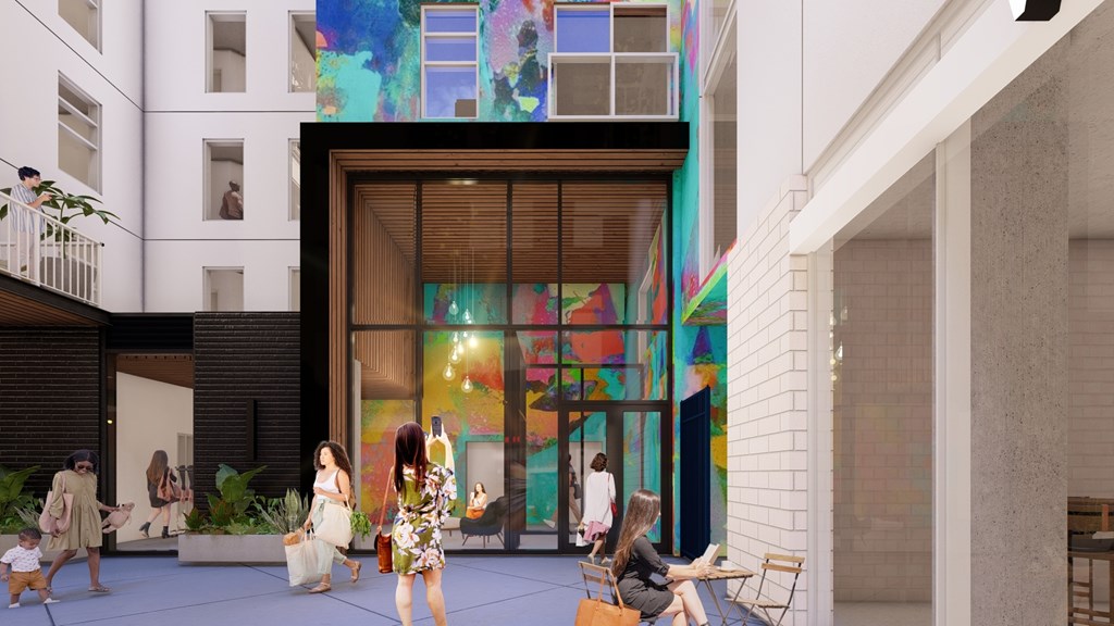 A group of people are walking in front of a colorful mural.