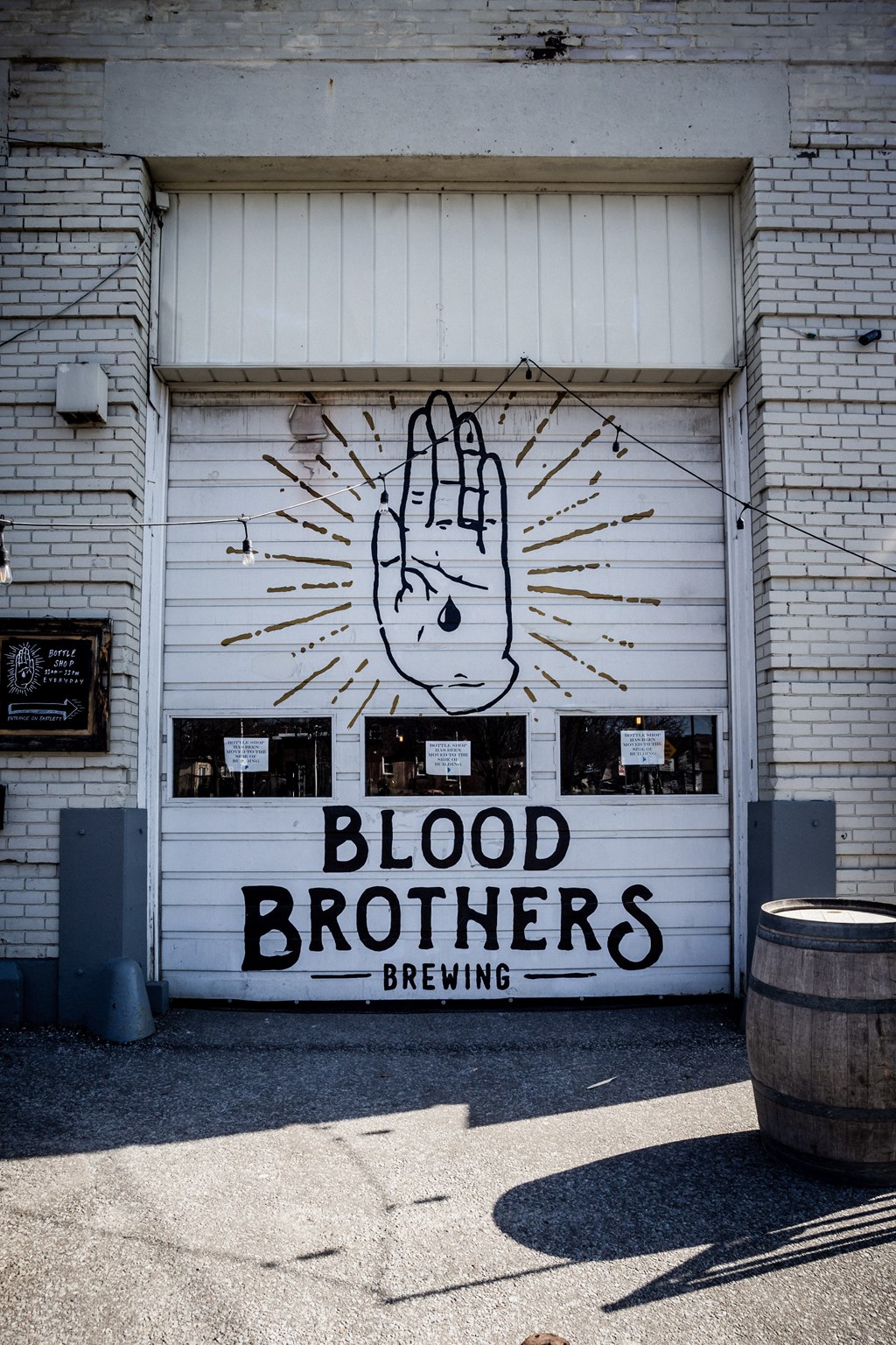 A mural of a hand with a peace sign is painted on a garage door.