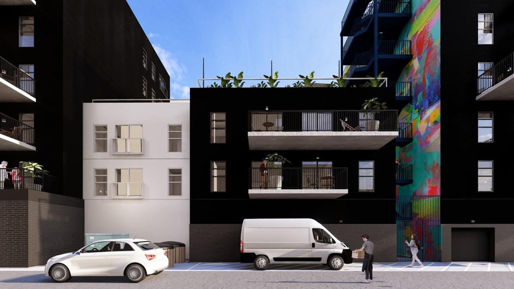 A white van is parked in front of a building with a mural on the side.