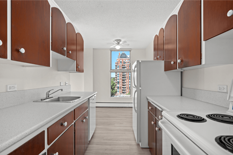 A kitchen with brown cabinets and a white stove top oven.