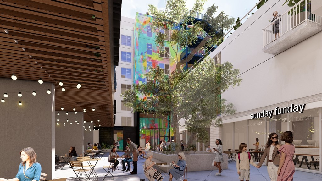 A group of people are sitting and standing around a courtyard.