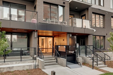 A modern building with a glass entrance and a balcony above it.