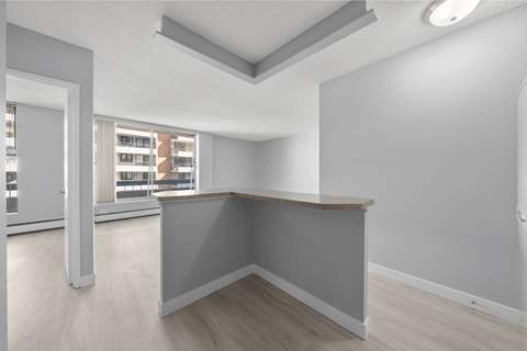 A spacious room with a grey wall and a wooden counter.