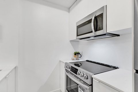 A modern kitchen with a stove and microwave.
