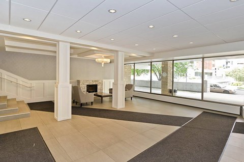 A spacious lobby with a staircase and a fireplace.
