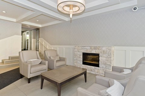A living room with a fireplace and two chairs.