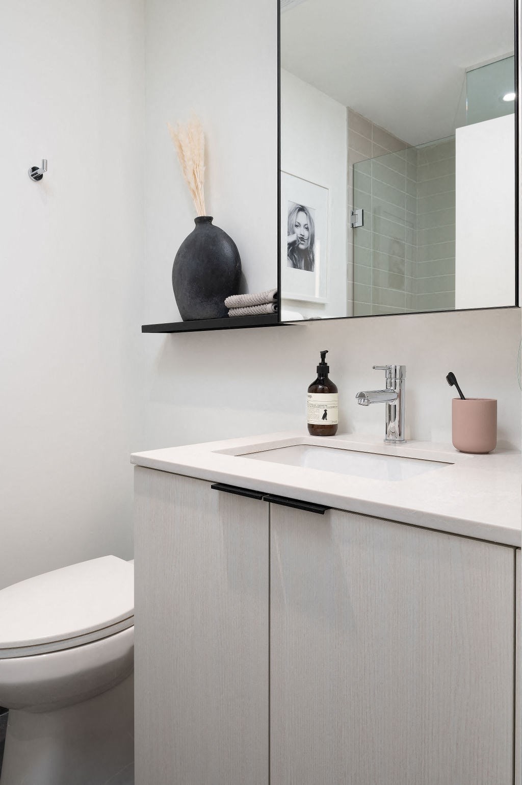 A bathroom with a white counter top and a toilet.
