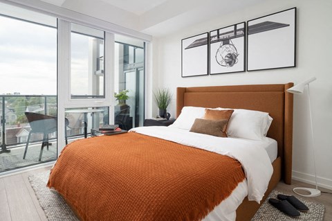 A bedroom with a large bed and a view of the city.