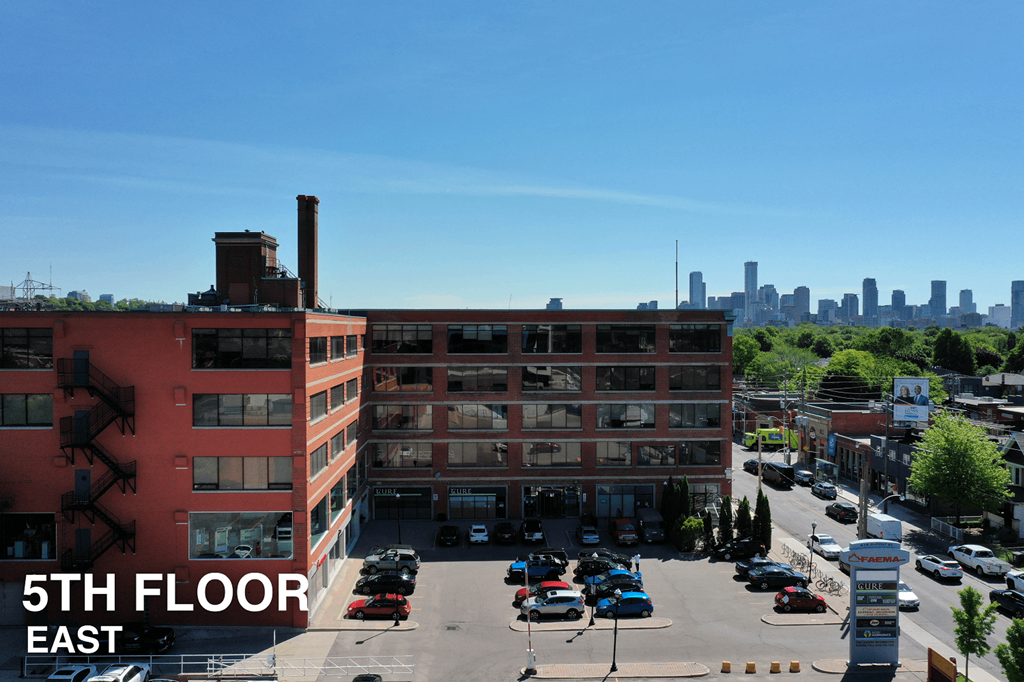 A parking lot with cars and a building in the background.