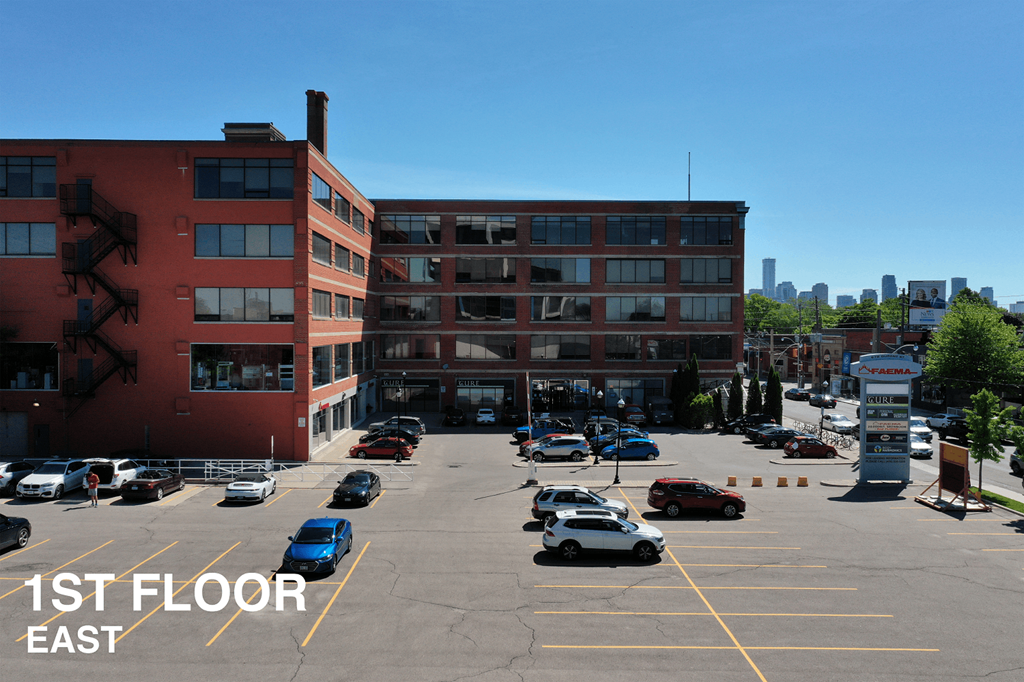 A parking lot with cars and a sign that says 1st Floor East.