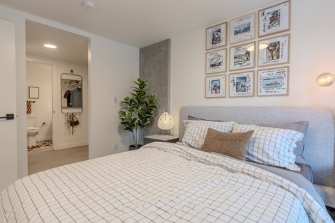 A bedroom with a large bed and pictures on the wall.