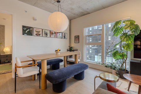 A living room with a white table and blue ottoman.