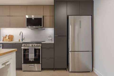 A modern kitchen with a stainless steel refrigerator and oven.