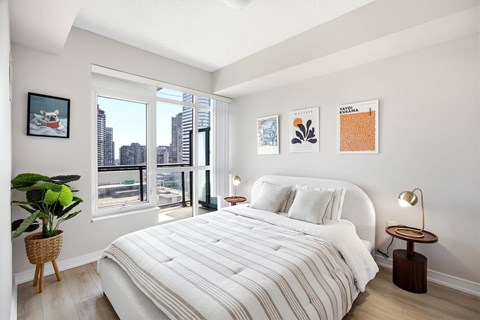 A bedroom with a large bed and a view of the city.