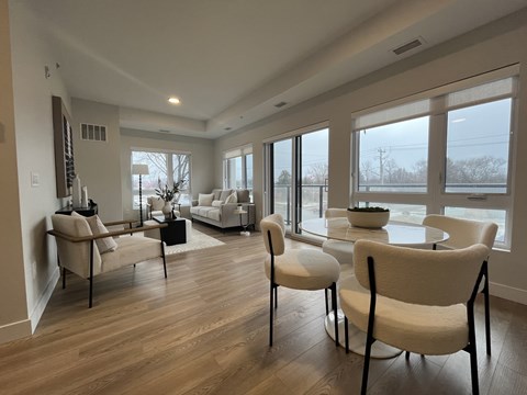 A living room with white furniture and a large window.