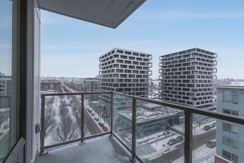 A view from a balcony looking out at a snowy landscape and buildings.