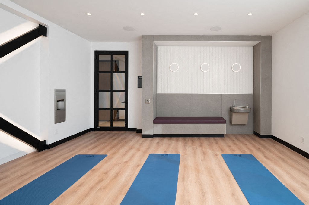 A yoga studio with blue mats on the floor.