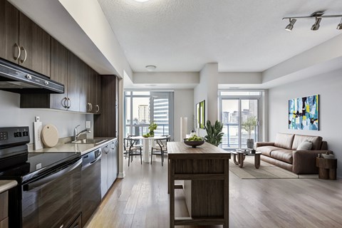 A modern kitchen with dark wood cabinets and stainless steel appliances.