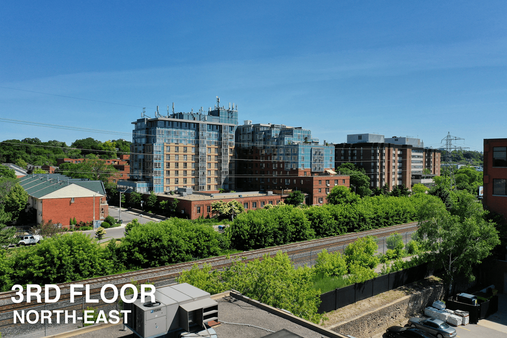 A view of a cityscape with a railway track in the foreground and buildings in the background.