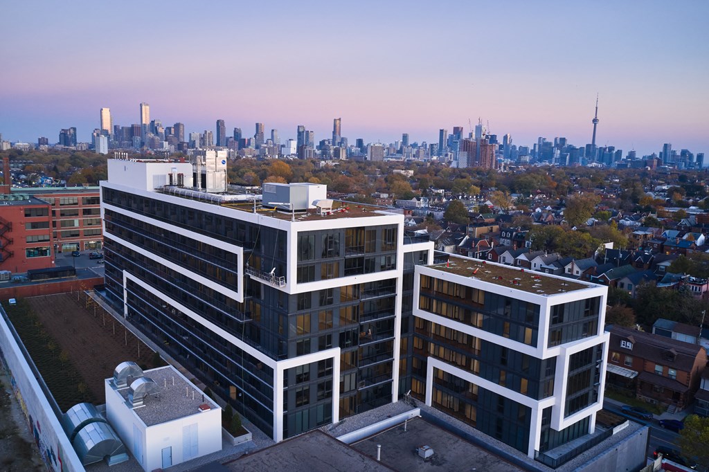 A cityscape with a large building in the foreground and a city skyline in the background.