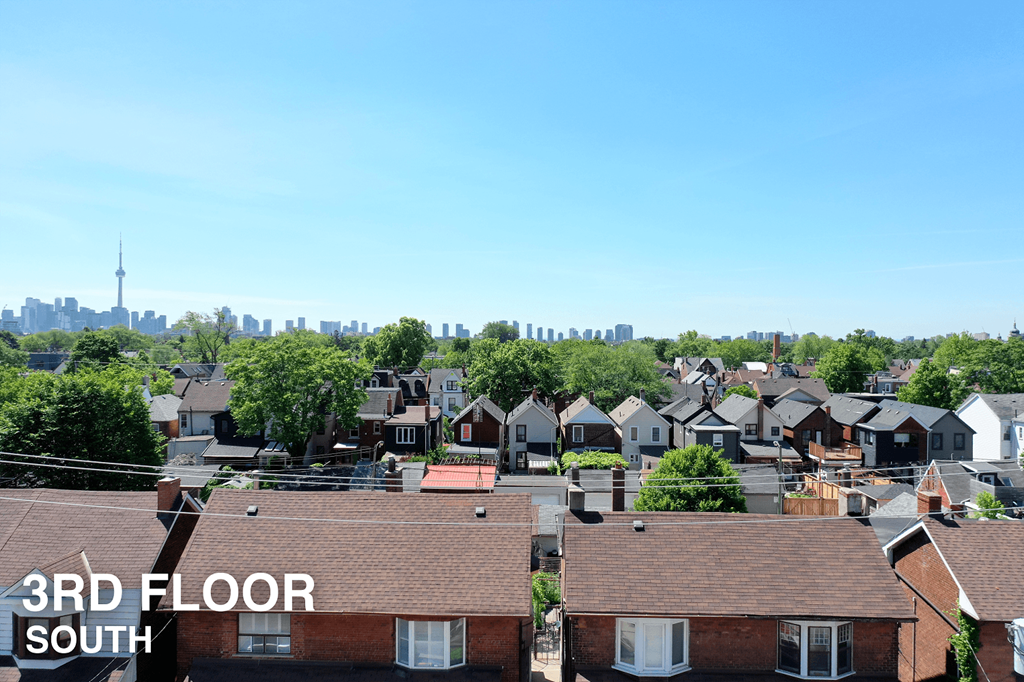 A view of a residential area with houses and a city skyline in the background.