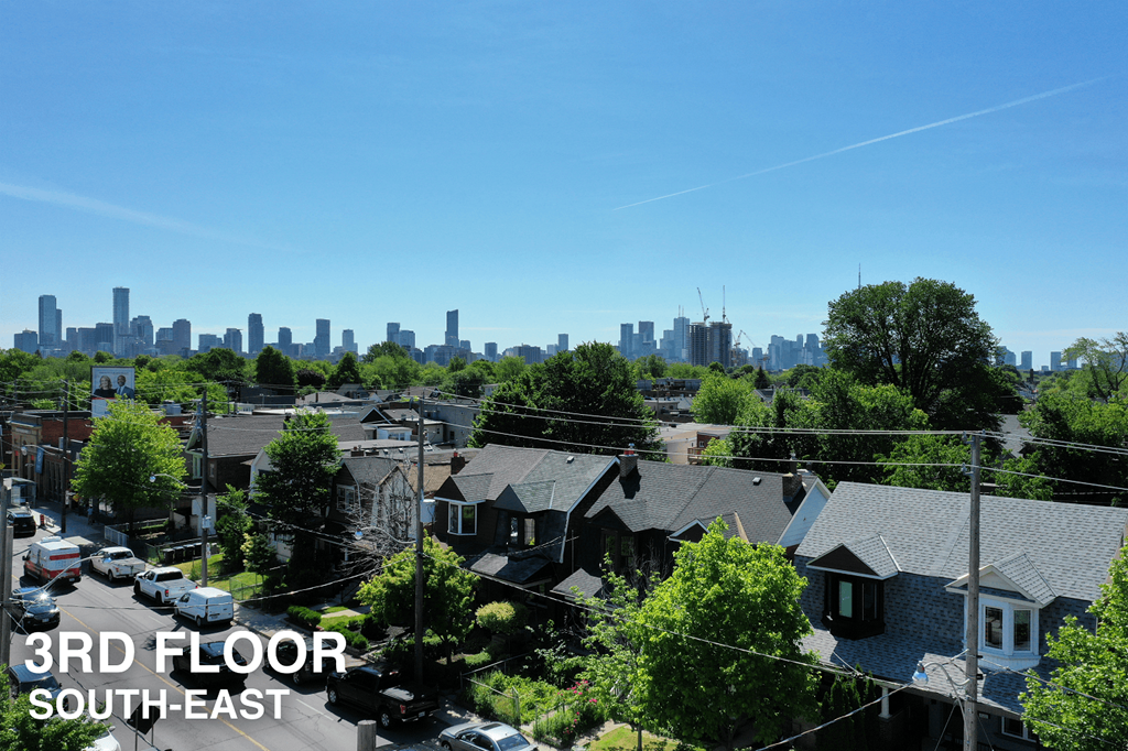 A view of a residential area with houses and a city skyline in the background.