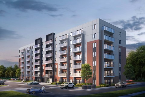 A modern apartment building with cars parked in front.