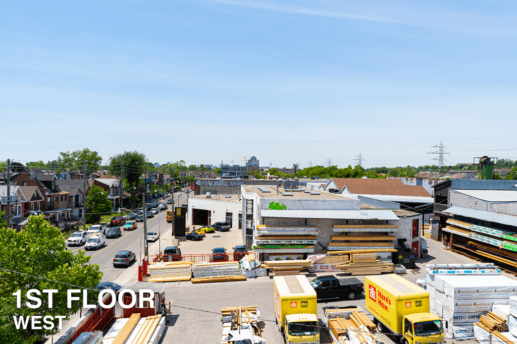 A parking lot with a yellow truck and a sign that says 1st Floor West.