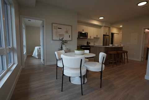 A dining room with a table and chairs.
