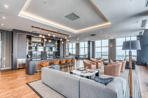 A modern living room with a grey sofa and a wooden floor.