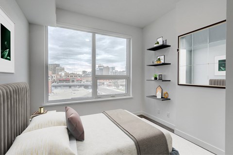 A bedroom with a large bed and a view of the city.