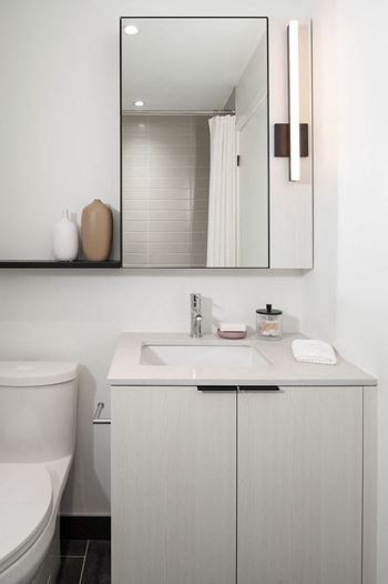 A white bathroom with a sink and a mirror.