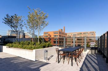 A table and chairs are set up on a rooftop patio.
