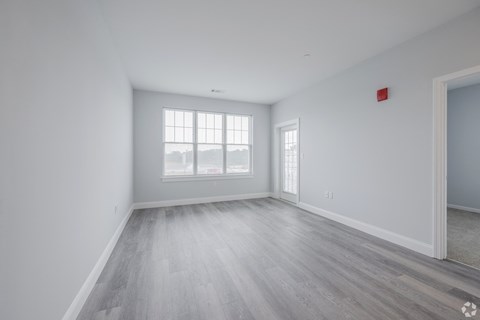 A room with a large window and a wooden floor.