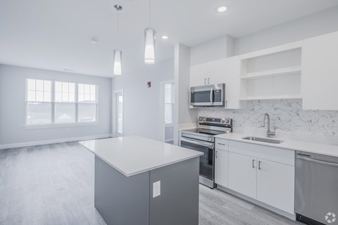 A modern kitchen with a large island and stainless steel appliances.