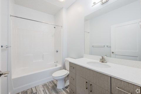 A white toilet sits in a bathroom next to a sink.