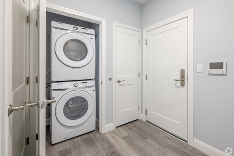 A white door is open to a laundry room with a washer and dryer.