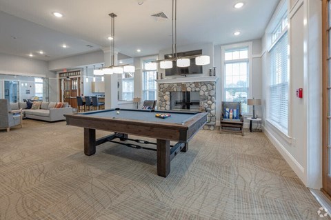 a large living room with a pool table and a fireplace
