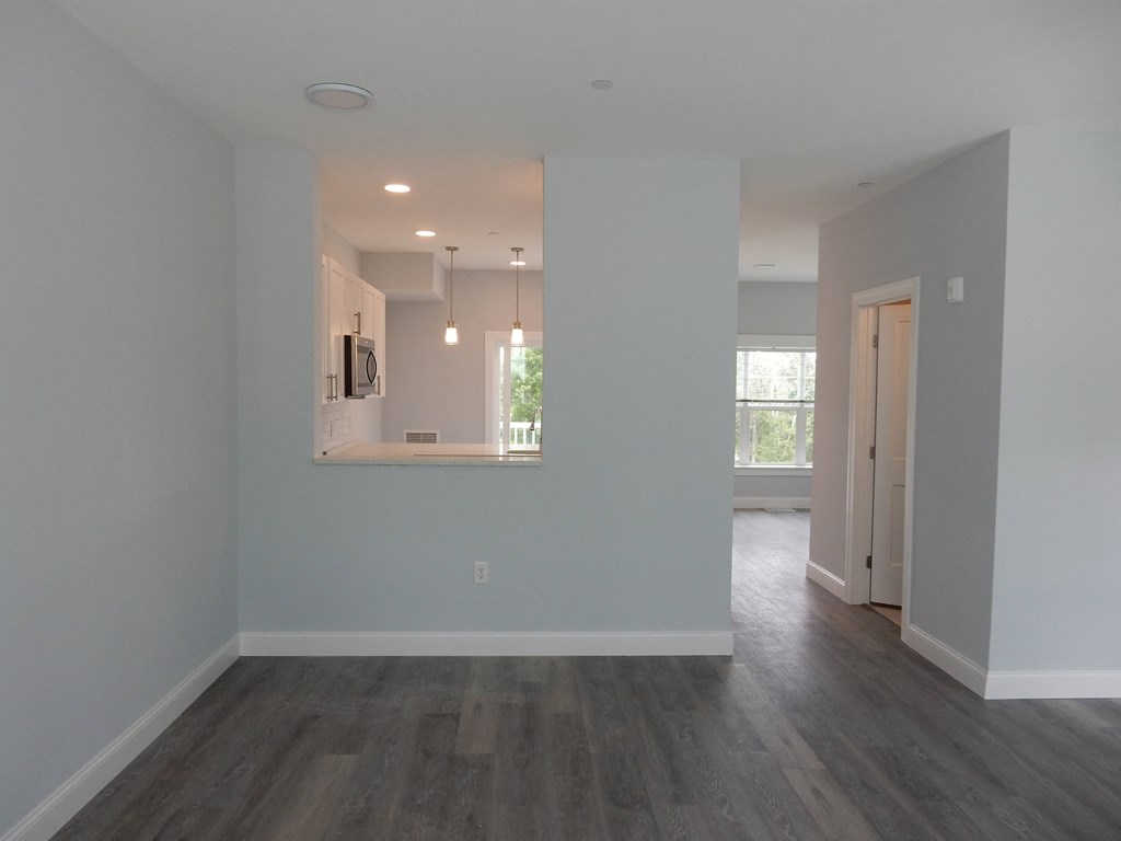 an empty living room with white walls and wood floors