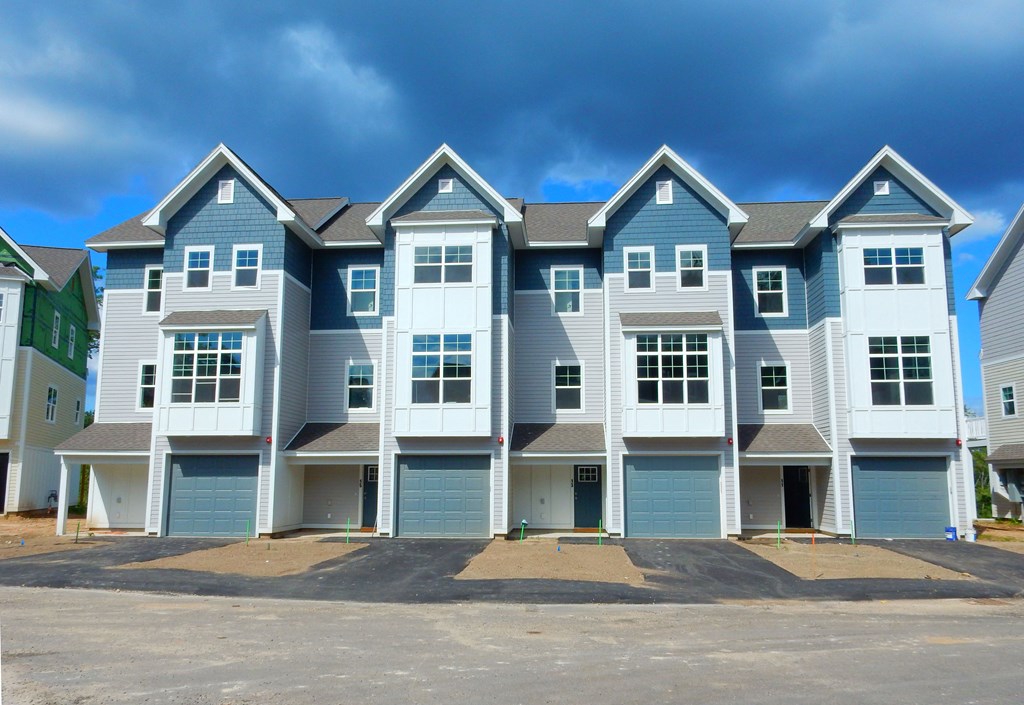 a row of town houses with blue and white siding and a cloudy sky